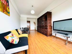 a living room with a couch and a large flat screen tv at Faro Family Apartment in Faro