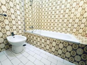 a bathroom with a toilet and a tub and a sink at Faro Family Apartment in Faro +49 photos