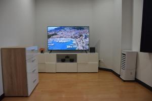 a living room with a flat screen tv on a dresser at La Maison des Trois in Beausoleil