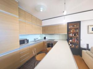 eine Küche mit Holzschränken und einer Arbeitsplatte in der Unterkunft Premium Seafront Suite in Thessaloniki