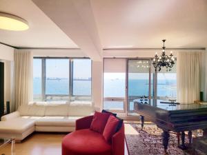 ein Wohnzimmer mit einer Couch und einem Klavier in der Unterkunft Premium Seafront Suite in Thessaloniki