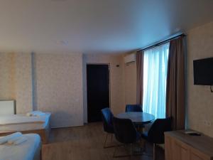a hotel room with a bed and a table and chairs at Panorama RABATI in Akhaltsikhe