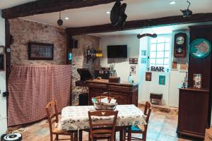 a dining room with a table and a table and chairs at Le Logis du Rocher in Saint-Marcet