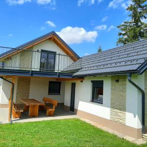 a house with a picnic table and a balcony at Haloze na dlani - Haloze in your hand, hiša s pogledom na hribe - a house vith a view of hills in Gruškovec