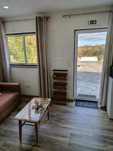 ein Wohnzimmer mit Sofa und Tisch in der Unterkunft Quintinha das Artes - Turismo Rural in Pinhel