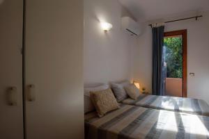 a bedroom with a bed and a window at Villetta Vista Paradiso in Costa Paradiso