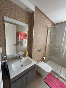 a bathroom with a sink and a shower and a toilet at New Sweet Home Soukra in Sukrah +13 photos