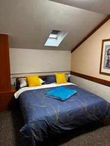 a bedroom with a bed with yellow and blue pillows at Baroko Rooms & Apartments in Varaždin