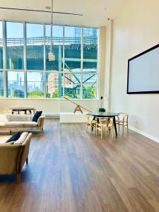 een woonkamer met een tafel en stoelen en een scherm bij Elegant Long Island City Studio with Skyline Views in Roosevelt Island