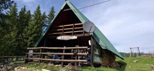 a barn with a green roof with a sign on it at Stan na dan Čajniče in Čajniče