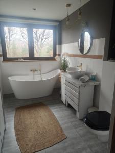 a bathroom with a tub and two sinks and a window at Apartament Graniczna in Bieniewice