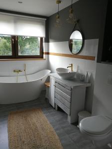 a bathroom with a tub and a sink and a toilet at Apartament Graniczna in Bieniewice +6 photos