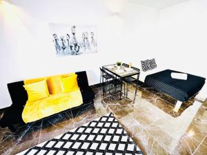 a living room with a yellow couch and a table at Studio com vista para Rua da Oura - Albufeira in Albufeira +22 photos