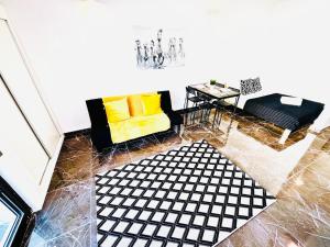 a living room with a yellow couch and a table at Studio com vista para Rua da Oura - Albufeira in Albufeira