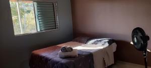a room with a bed and a window and a fan at Casa do Mirante in Alto Paraíso de Goiás