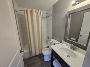 Un baño con lavabo, inodoro y espejo. en Motel 6 East Windsor, NJ Hightstown, en East Windsor