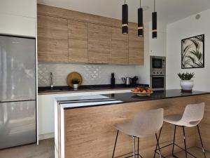 une cuisine avec des comptoirs noirs et des armoires en bois dans l'établissement Thai Beach Residencial E - Sea View, à Santiago de la Ribera