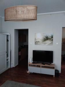 un salon avec une télévision à écran plat sur un mur dans l'établissement Apartament Haffnera, à Sopot