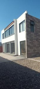 ein großes weißes Gebäude mit Fenstern auf einer Straße in der Unterkunft Guest HOUSE HUMEDAL in Arica