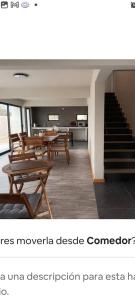 Zimmer mit Holztischen, Stühlen und Treppen in der Unterkunft Guest HOUSE HUMEDAL in Arica