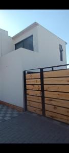 ein Haus mit einem Holzzaun und einem Gebäude in der Unterkunft Guest HOUSE HUMEDAL in Arica
