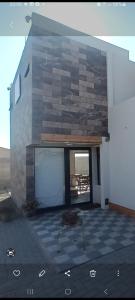 ein Gebäude mit einer Steinmauer und einer Terrasse in der Unterkunft Guest HOUSE HUMEDAL in Arica