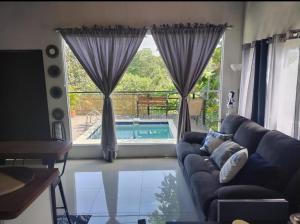 a living room with a couch and a large window at Fruta de mango #2 in Lagunillas +6 photos