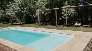 a swimming pool in a yard with a picnic table at La Posada de Buda in Malargüe