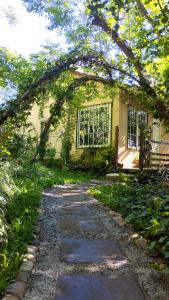 einen Steinweg, der zu einem Haus mit Fenster führt in der Unterkunft Entre Árboles in San Salvador de Jujuy