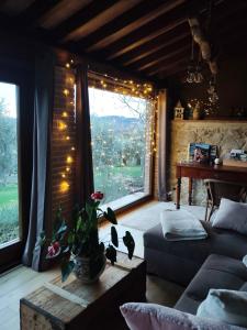 un salon avec un canapé et une fenêtre avec des lumières dans l'établissement Cottage La Dolce Agogia Panicale, à Panicale