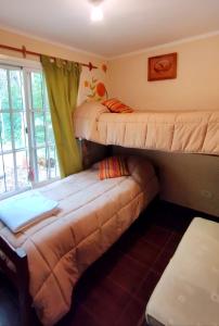 2 Etagenbetten in einem Zimmer mit einem Sofa in der Unterkunft Entre Árboles in San Salvador de Jujuy