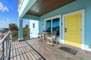 a house with a yellow door on a deck at Salty waves 2 in Flagler Beach