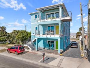 a blue house with a red car parked in front of it at Salty waves 2 in Flagler Beach