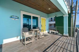 a patio with chairs and a table on a deck at Salty waves 2 in Flagler Beach