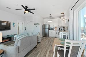 a living room with a couch and a ceiling fan at Salty waves 2 in Flagler Beach +19 photos
