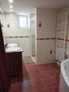 un bagno con due lavandini, una doccia e una vasca di Belle maison de campagne au calme a Chey