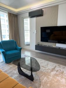 a living room with a blue couch and a glass coffee table at A2I - 33rd Floor SkyCity Residence With Skopje View in Skopje