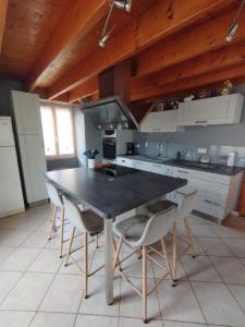 una cucina con un tavolo e sedie in una stanza di Belle maison de campagne au calme a Chey