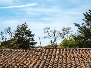 a tile roof with trees in the background at D'une maison à l'autre in Cépie