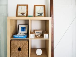 a wooden shelf with pictures and other items on it at D'une maison à l'autre in Cépie +15 photos