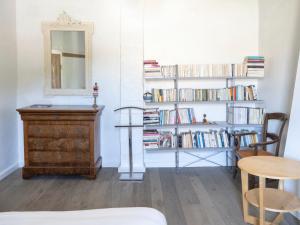 a room with a dresser and a mirror and books at D'une maison à l'autre in Cépie