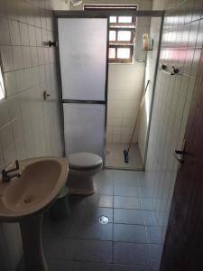 a bathroom with a toilet and a sink at Casa Tupy próxima a praia e restaurantes in Praia Grande +19 photos