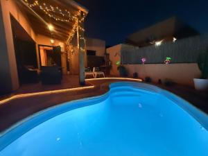 a swimming pool in a backyard at night at Dar Nur Villa Private pool, Barbecue and Solarium in La Oliva