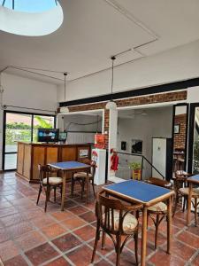 ein Zimmer mit Tischen und Stühlen sowie einer Küche in der Unterkunft Santa Catalina Hotel in San Antonio de Areco