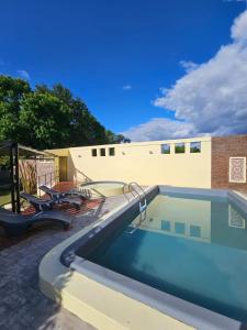 einen Pool in einem Hof mit einem Gebäude in der Unterkunft Santa Catalina Hotel in San Antonio de Areco