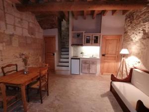 阿尔勒Extraordinaire face aux Arènes的客厅里有一张桌子和一个厨房