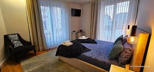 une chambre avec un lit, une chaise et des fenêtres dans l'établissement Je T'aime Solar São João, à São João da Madeira