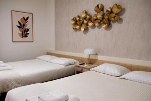 Cette chambre comprend deux lits et un lustre. dans l'établissement Je T'aime Solar São João, à São João da Madeira