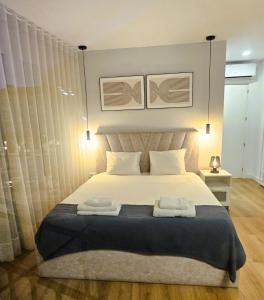 a bedroom with a large bed with two towels on it at Je T'aime Solar São João in São João da Madeira