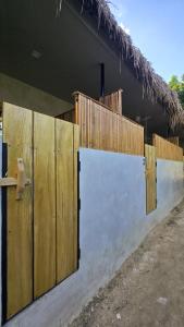 a fence with wooden doors in front of a building at Lagalag Studios in El Nido